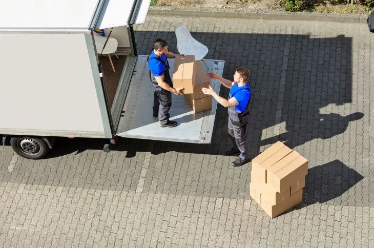 Umzugshelfer beim Entladen vor neuem Haus Umzugshelfer beim Entladen vor neuem Haus
